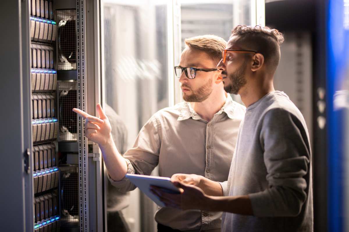 Two IT Specialists In A Server Room Who Work Within The IT Sector